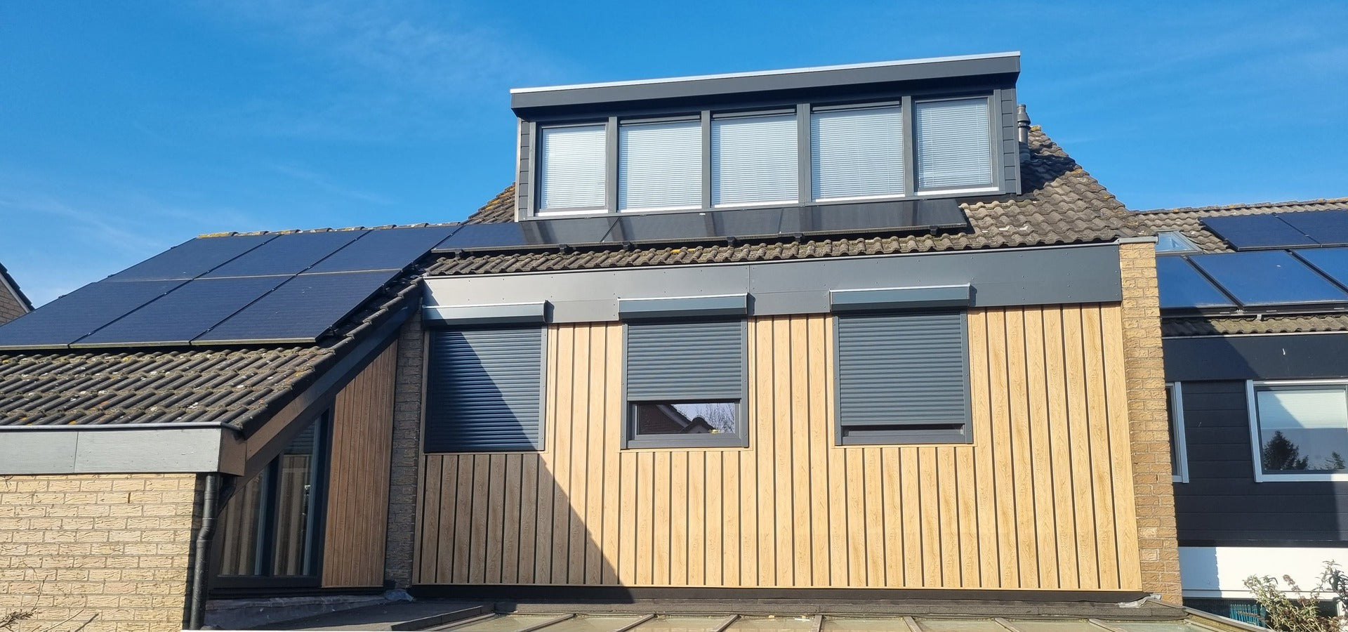 Woning afgewerkt met kunststof bouwmateriaal en houtlook gevelbekleding.