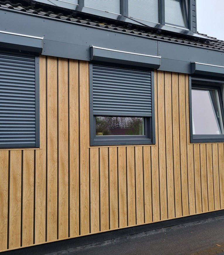 Woning met houtlook kunststof gevelbekleding en antraciete kozijnen.